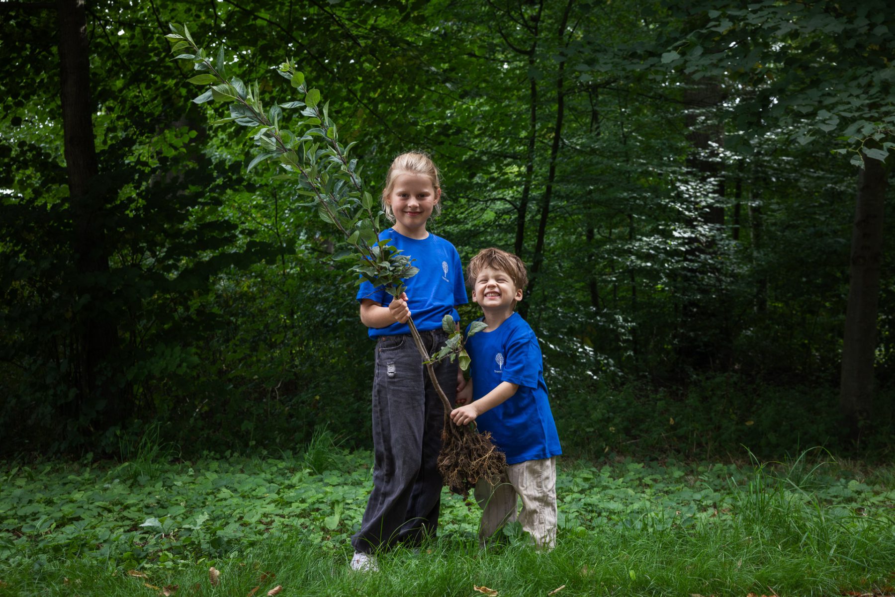 Twee kinderen planten een boompje